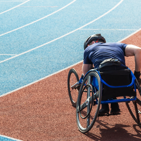 A man in a wheelchair is standing on a treadmill